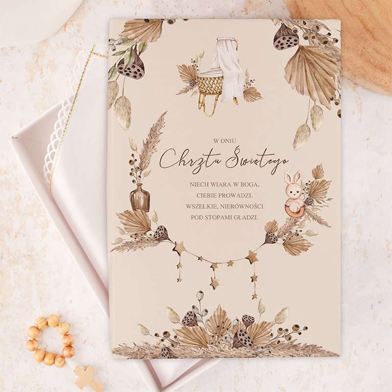 Zaproszenie na chrzest święty z dekoracyjnymi elementami roślinnymi, z ilustracjami, takimi jak zajączek, kontener z włóknami oraz zawieszony sznurek z gwiazdkami, zawierające tekst modlitwy w języku polskim na beżowym tle.