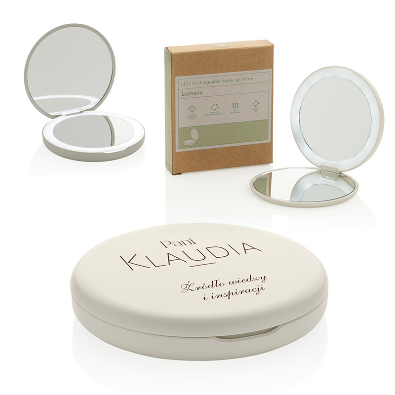 Lustro do makijażu z wbudowanym oświetleniem LED, otwarte, obok opakowanie z napisem 'LED rechargeable make-up mirror Lumora' oraz zamknięte, okrągłe lustro w kremowym etui z napisem 'Pani KLAUDIA'.
