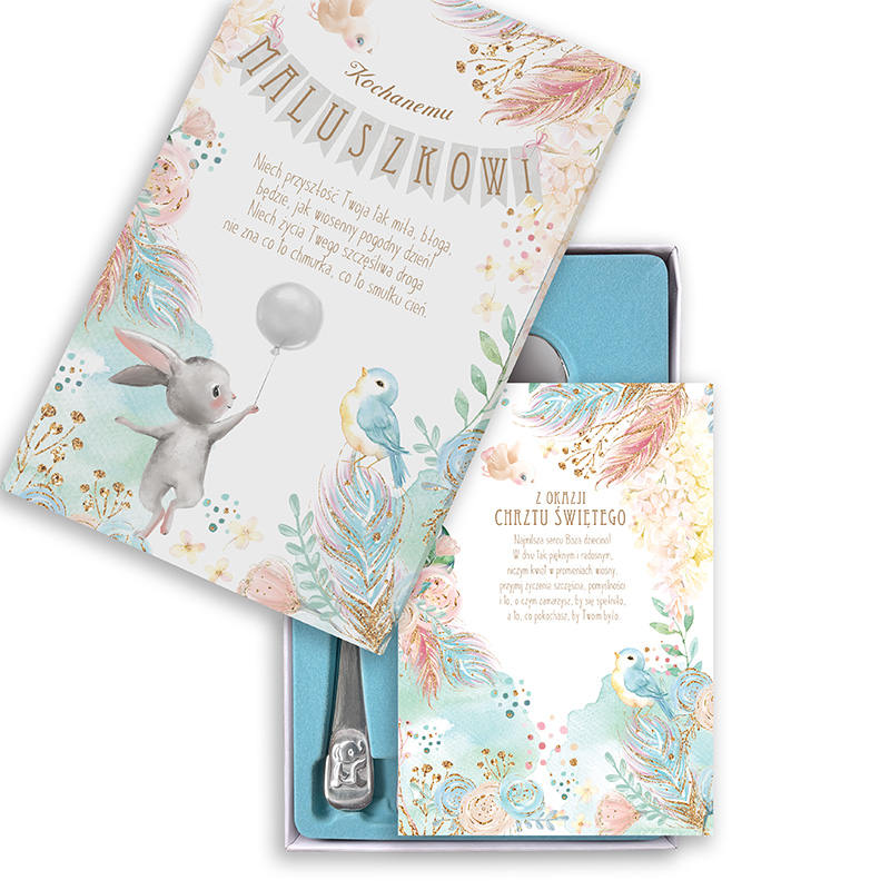 Kolorowe opakowanie z okazji chrztu, zawierające kartkę z życzeniami oraz srebrną łyżeczkę. Na kartce widnieje rysunek króliczka trzymającego balon oraz niebieskiego ptaszka, otoczonego pastelowymi kwiatami i liśćmi.
