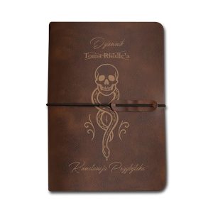 Skórzany dziennik z wytłoczonymi napisami "Dziennik Tomy Riddle'a", ozdobiony grafiką czaszki owiniętej w węża, zamknięty gumką.