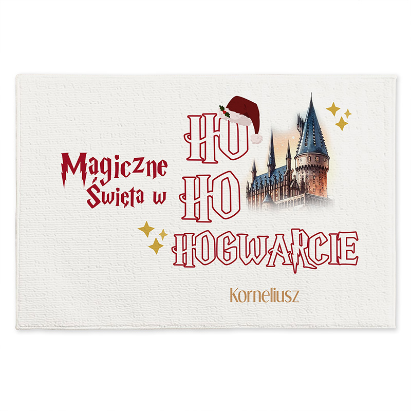 Grafika z napisem 'Magiczne Święta w HO HO HOGWARCIE' na białym tle, zawierająca ilustrację zamku z charakterystycznymi wieżami oraz czerwoną czapkę Świętego Mikołaja, obok złote gwiazdki i imię 'Korneliusz'.