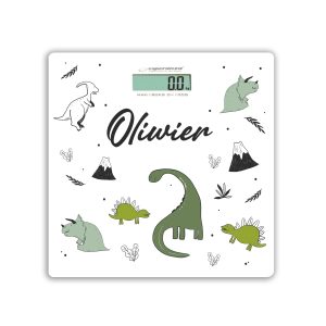 Waga elektroniczna o białym tle z kolorowymi rysunkami dinozaurów oraz napisem 'Olivier', wyświetlająca wartość 0.0 kg.