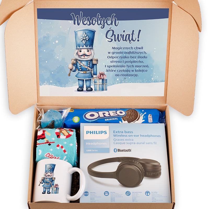 Karton z prezentami na święta, zawierający filiżankę z motywem nutcracker, słuchawki bezprzewodowe Philips, opakowanie ciastek Oreo, skarpetki w kolorowe wzory i paczkę słodyczy, z górną częścią kartonu zdobioną grafiką z napisem 'Wesołych Świąt!' i ilustracją strażnika.