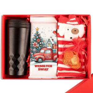 Zestaw prezentowy w czerwonym pudełku zawierający czarny kubek, czekoladę z ilustracją świątecznego samochodu i choinki, skarpetki w paski z motywem renifera oraz złote monetki czekoladowe.