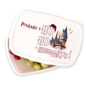 Pojemnik na przekąski z napisem 'przekąski z HO HO HOGWARTU', zdobiony rysunkiem zamku z wieżami i czapką Mikołaja, w środku widoczne czerwone i zielone winogrona.