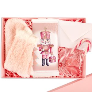 Różowa paczka prezentowa zawierająca miękkie skarpetki, opakowanie z wizerunkiem skaczącego żołnierza z prezentem, kopertę, oraz słodkości w torebce, w tym cukierki w kształcie serca i laskę cukrową.