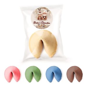 Opakowanie na słodycze zawiera duże ciastko, obok niego umieszczone są mniejsze ciasteczka w kolorach różowym, zielonym, niebieskim i brązowym, z etykietą "Dzień Babci i Dziadka" oraz wizerunkiem starszej pary.