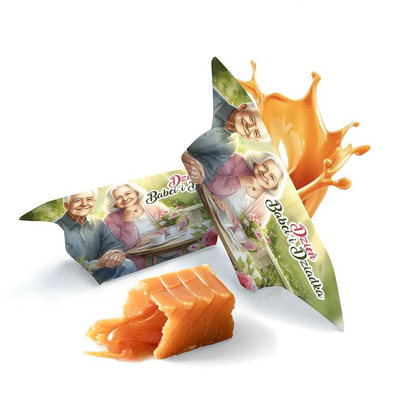 Opakowanie cukierków z grafiką przedstawiającą starszą parę przy wspólnym stole, obok leży kawałek cukierka w pomarańczowym kolorze, a z tła unosi się fala pomarańczowego płynu, na opakowaniu napis 'Dzień Babci i Dziadka'.