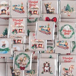 Pudełka z prezentami zdobione kolorowymi ilustracjami przedstawiającymi m.in. wóz z parowozem, zające, choinki i kominki, z napisami "Wesołych Świąt" na jasnym tle z delikatnym śniegiem.