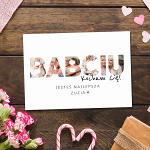 Kartka z napisem 'BABCIU Kocham Cię!' wypełnionym zdjęciami, z tekstem 'Jesteś najlepsza Zuzia' i sercem w dolnym rogu, otoczona różowymi kwiatami i cukierkami w kształcie serca na drewnianym tle.