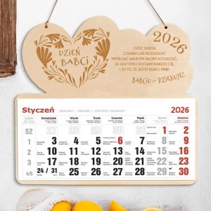 Drewniany kalendarz na 2026 rok z napisem "Dzień Babci" oraz dekoracyjnym wzorem liści i serca, z miesiącem styczeń na dole, zawierający daty i dni tygodnia w polskim i czterech innych językach.
