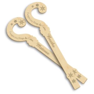 Dwa drewniane gwiazdki w kształcie laski cukrowej z wygrawerowanym napisem 'Świąteczna Różga dla Ciebie' oraz imionami 'Beatrka' i 'Mateuszy', zdobione śnieżynkami.