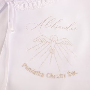 Biała szata z haftem przedstawiającym postać z anielskimi skrzydłami oraz napisem "Pamiątka Chrztu Św." i imieniem "Aleksander" w eleganckiej czcionce.