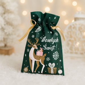 Zielony worek na prezenty z rysunkiem renifera niosącego pakunek i napisem "Wesołych Świąt!", ozdobiony śnieżynkami i innymi motywami świątecznymi, na tle rozmytych światełek.
