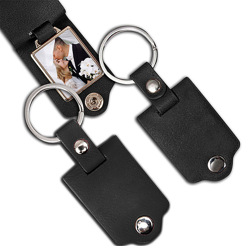 Czarny brelok do kluczy z miejscem na zdjęcie, na którym widać parę młodą. Dwie pętle na klucze z metalowymi okręgami i zatrzaskami.