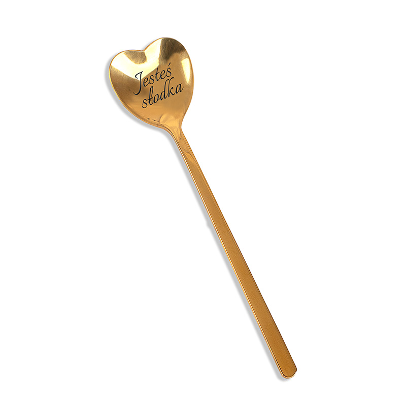 Złota łyżka w kształcie serca z napisem "Jesteś słodka" na końcu uchwytu.