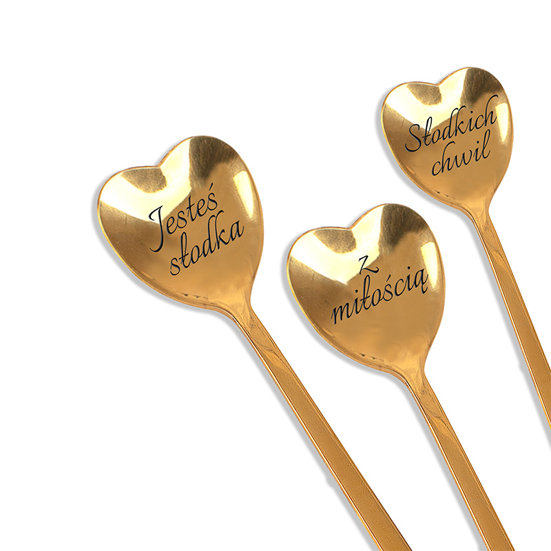 Trzy złote łyżeczki w kształcie serca, z inskrypcjami: 'Jesteś słodka', 'Z miłością' oraz 'Słodkich chwil'.