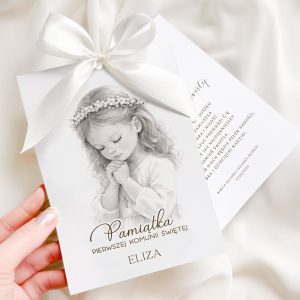 Kartka z okazji I Komunii Świętej z wizerunkiem dziewczynki modlącej się, z delikatnym koronkowym wiankiem na głowie i białą wstążką na górze, tekst w złotym kolorze i imieniem 'ELIZA' poniżej.