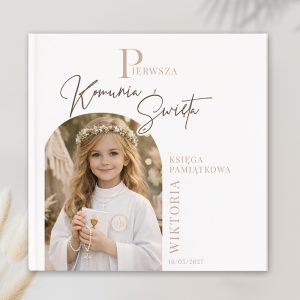 Księga pamiątkowa z napisem "Pierwsza Komunia Święta", przedstawiająca dziewczynkę w białej szacie i z koronką na głowie.