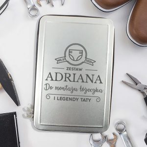 Srebrne etui z napisem "Zestaw Adriana do montażu tężeczka i legendy taty", otoczone narzędziami i butami.