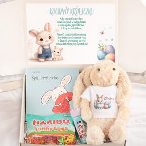 Karton z prezentem zawierający pluszowego królika, słodycze oraz kartkę z życzeniami.