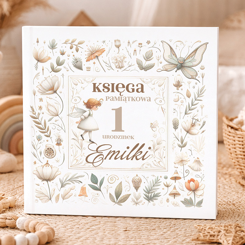 Księga pamiątkowa z okazji pierwszych urodzin Emilki, ozdobiona delikatnymi ilustracjami kwiatów i postaci.