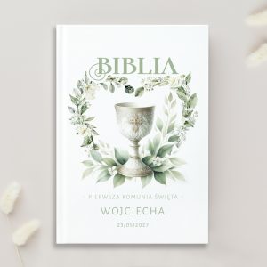 Biblia ozdobiona ilustracją kielicha i zielonych liści, z napisem "Pierwsza Komunia Święta" oraz datą.
