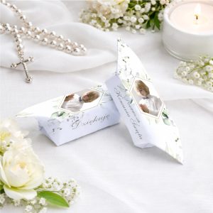 Elegancka kompozycja zawierająca dwie krówki z delikatnym zdobieniem, kwiatami i zdjęciem chłopca.