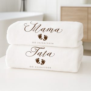 Ręczniki z napisem „Mama” i „Tata” oraz stempelkami stóp, datą, ułożone na białym tle.