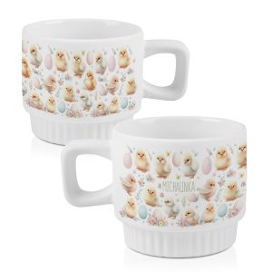 Dwa kubki ceramiczne z białym tłem, ozdobione ilustracjami małych kurczaczków i pisankami z imieniem.