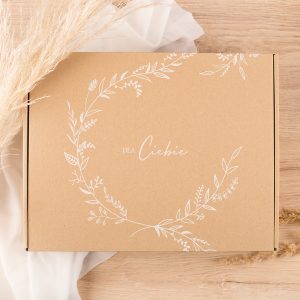 Brązowe pudełko z białym, roślinnym wzorem i napisem "DLA CIEBIE".