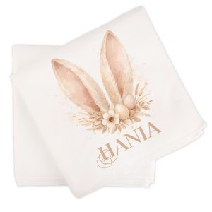 recznik-z-zajaczkiem.jpg Ręcznik z dekoracją w postaci uszu zająca, kwiatów i jajek, z imieniem w eleganckim stylu na dolnej części.