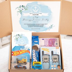 Pudełko z prezentem z okazji chrztu, zawierające książkę, zabawki, słodycze i broszurę z imieniem