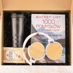 Zestaw prezentowy zawierający notes "Bucket List", słuchawki, kubek oraz czekoladki Ferrero Rocher, umieszczony w pudełku.