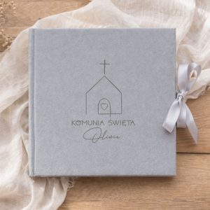 Szary album fotograficzny z logo kościoła, napisem "Komunia Święta" oraz imieniem , przewiązany wstążką.