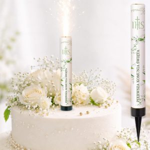 Zapalająca się świeczka na torcie udekorowanym białymi kwiatami i gałązkami, z napisem "Pierwsza Komunia Święta".