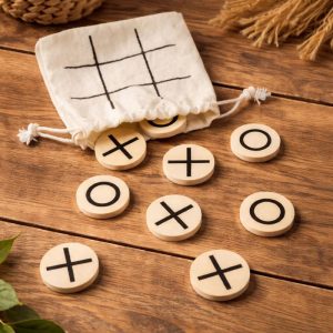 kolko-krzyzyk-gra.jpg Zestaw do gry w kółko-krzyżyk składający się z okrągłych drewnianych żetonów z nadrukiem „X” i „O”, leży na stole obok woreczka.