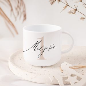 Biała filiżanka z napisem "IMIĘ" i dużą, stylizowaną cyfrą "1". Tło z lekkimi roślinnymi akcentami.