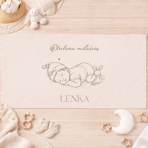 Niemowlę śpiące w różowej czapeczce obok pluszowego króliczka, z napisem „Otulona miłością” i imieniem.