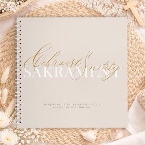 Okładka albumu na chrzest, z napisem "Sakrament Święty" w eleganckiej czcionce, na tle jasnego materiału i dekoracji.