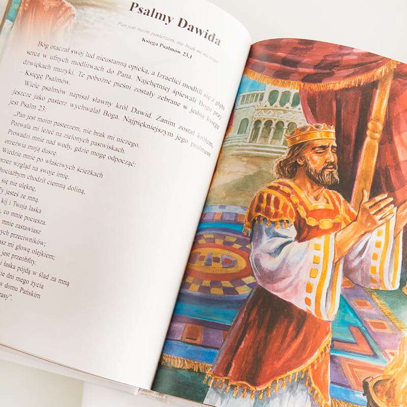 Otwarte strony książki z ilustracją króla Dawida w szatach królewskich, stojącego w majestatycznym pałacu.