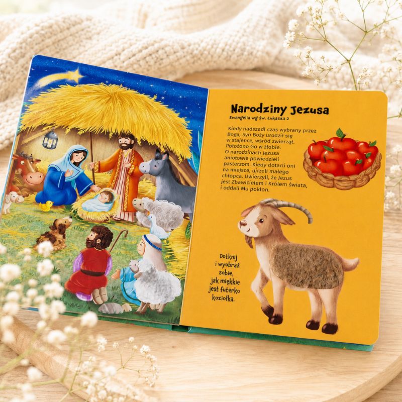 Ilustracja przedstawia scenę narodzin Jezusa w stajence, z postaciami religijnymi i zwierzętami.