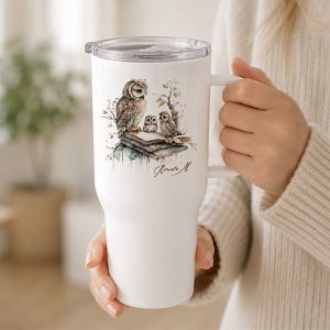 kubek-termiczny-dla-nauczyciela-z-personalizacja.jpg Kubek termiczny z ilustracją sowy, trzymany przez osobę w jasnym swetrze.