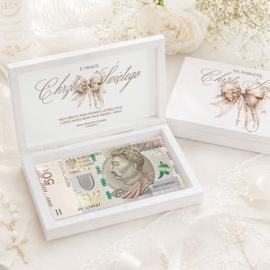 Biała szkatułka z banknotem 500 złotowym, ozdobiona napisem "Z okazji Chrzcin Świętych" oraz elementami dekoracyjnymi.