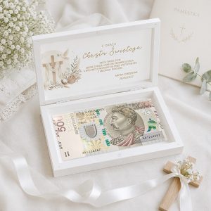 personalizowana-szkatulka-na-pieniadze-dla-dziecka-na-chrzest.jpg Biała skrzynka z napisem "Z okazji Chrztu Świętego" zawiera banknot, otoczona dekoracjami i kwiatami.