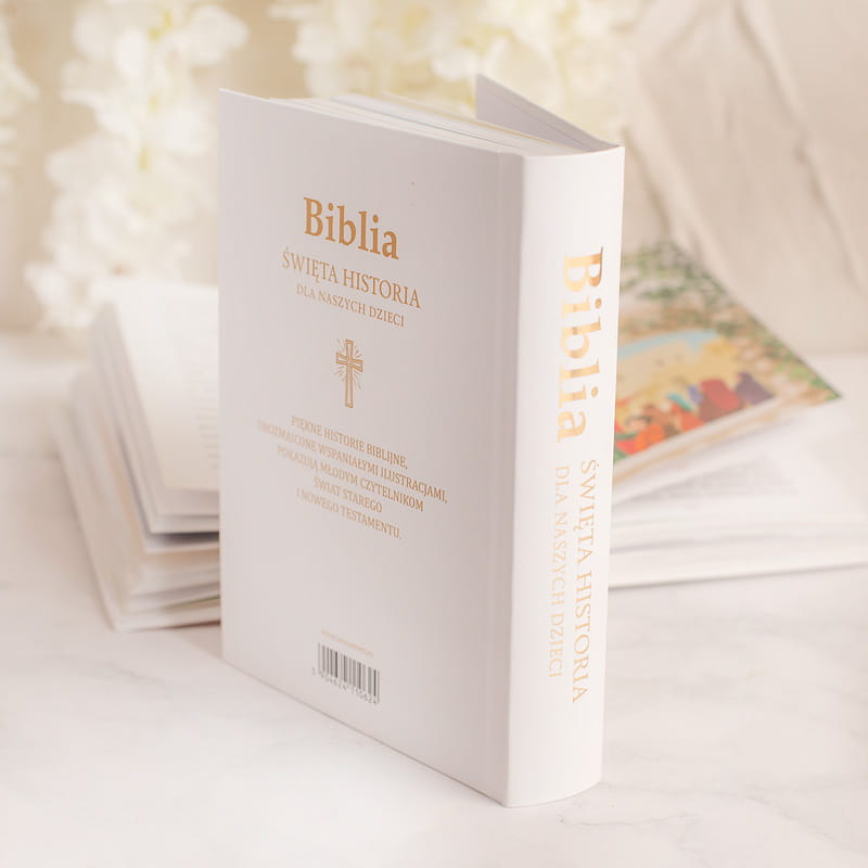 Biblia z napisem "Święta Historia dla naszych dzieci", z ilustracjami i złotym tytułem na białej okładce.