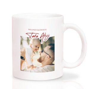bialy-kubek-ze-zdjeciem-dla-taty-na-dzien-taty.jpg Biały kubek z napisem "Najlepszy na świecie Tata" oraz zdjęciem ojca trzymającego uśmiechnięte niemowlę.