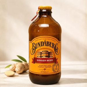 Fermentowany napój imbirowy w szklanej butelce pokazany z imbirem i liśćmi jako produkt premium.