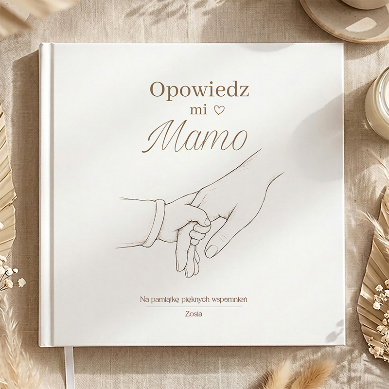 Biały album z rysunkiem ręki dorosłej osoby trzymającej dłoń dziecka oraz napisem "Opowiedz mi Mamo".