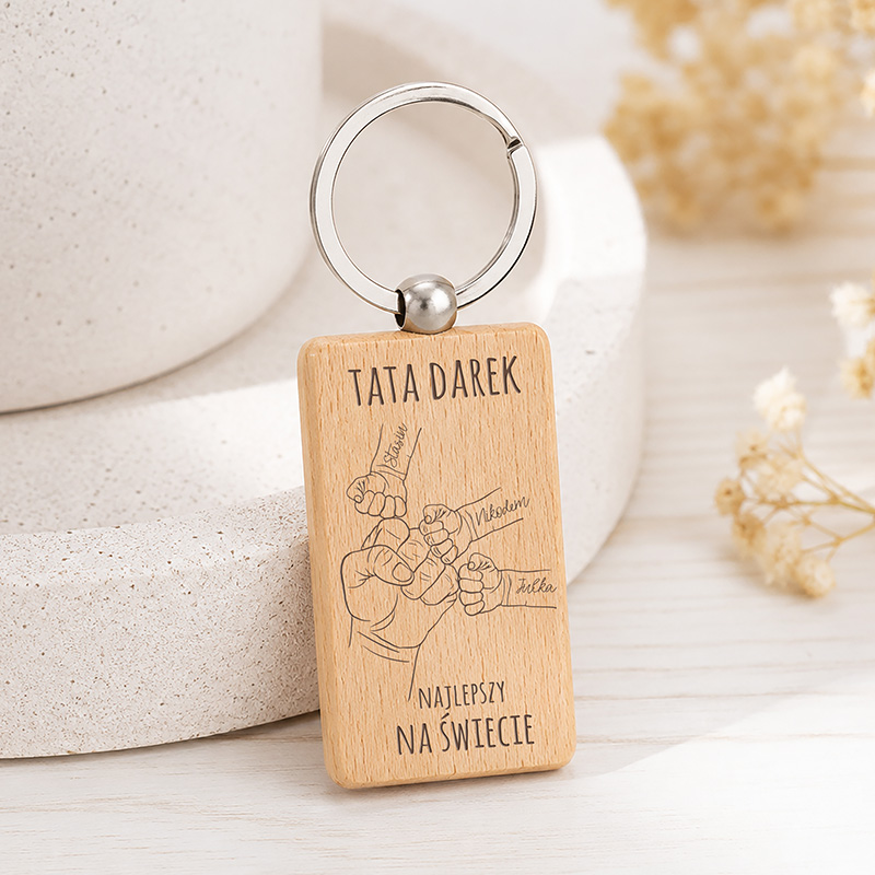 Brelok z drewna z napisem "TATA DAREK NAJLEPSZY NA ŚWIECIE" oraz rysunkiem pięści.